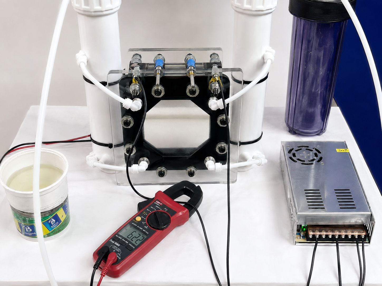 Full experimental cell setup with acrylic assembly, tubing, power source and measuring equipment.